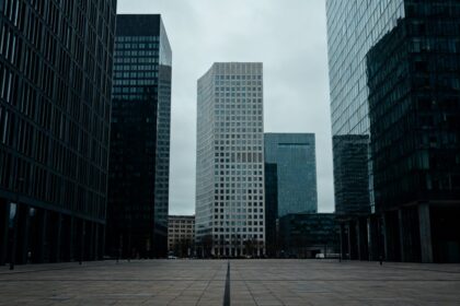 Quartier d'affaires europeen aux tours de bureaux sous un ciel gris, esplanade deserte.