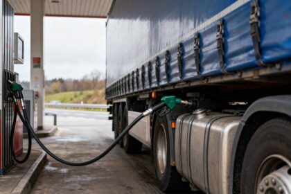 Camion de transport routier en cours de ravitaillement en gazole à la pompe d'une station-service d'autoroute