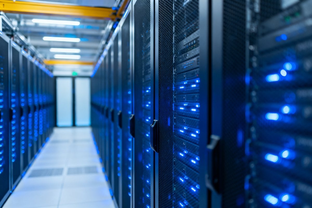 Allées de serveurs informatiques éclairées de bleu dans un centre de données moderne