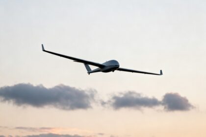 Un drone de surveillance à voilure fixe en vol dans un ciel nuageux au crépuscule