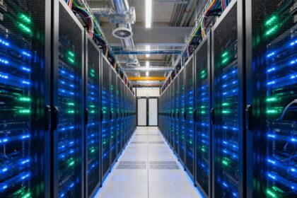Salle de centre de données avec rangées de serveurs illuminés et infrastructure de refroidissement.