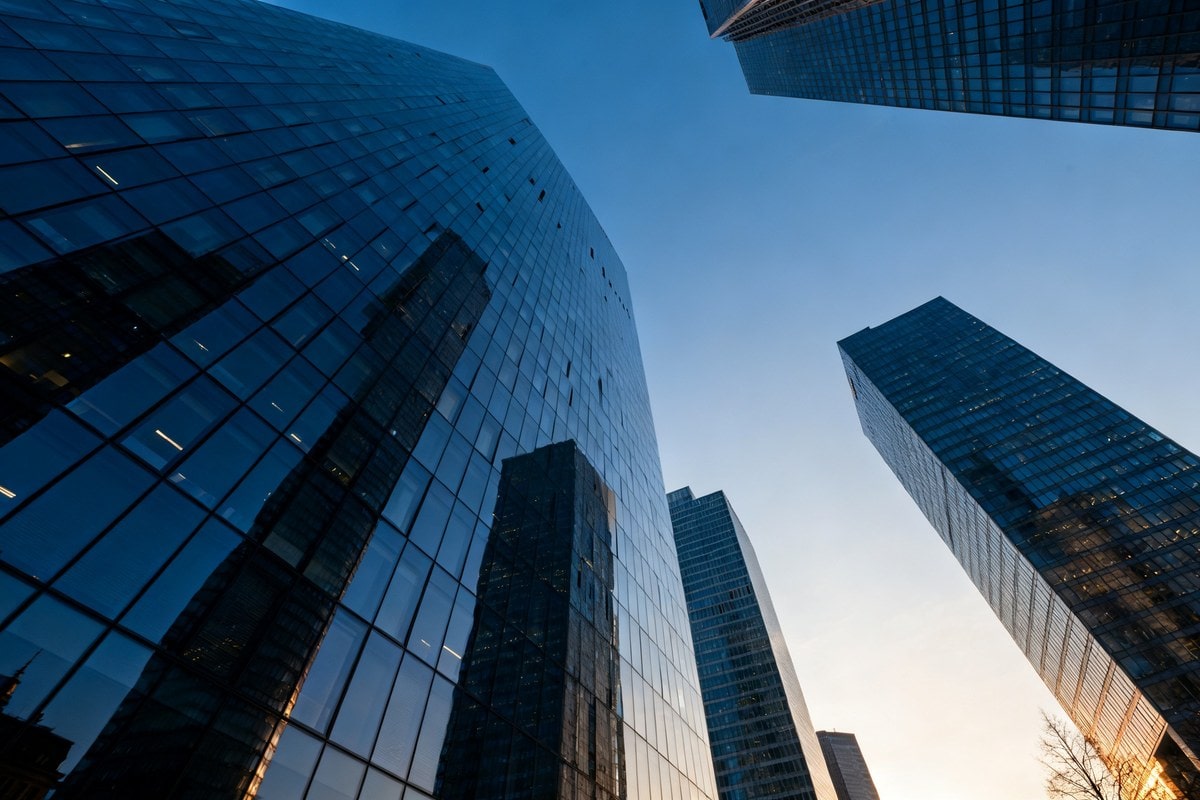 Tours de bureaux en verre d'un quartier d'affaires vues en contre-plongée sous un ciel bleu